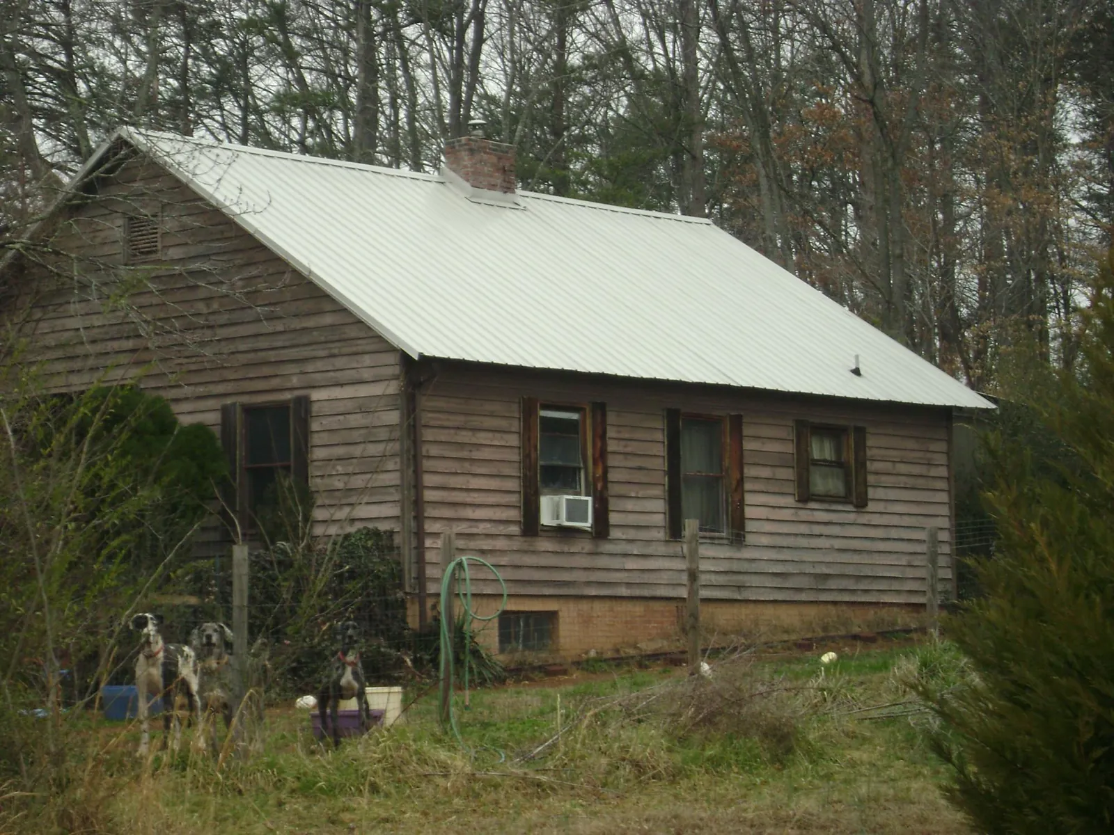 White metal roof on an old wood sided farmhouse, from a Metal Roof Installation job in Coloma